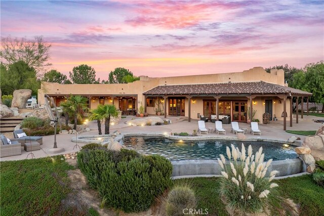 back house at dusk with a patio