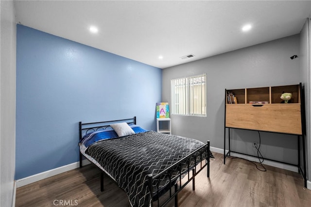 bedroom with recessed lighting, visible vents, baseboards, and wood finished floors