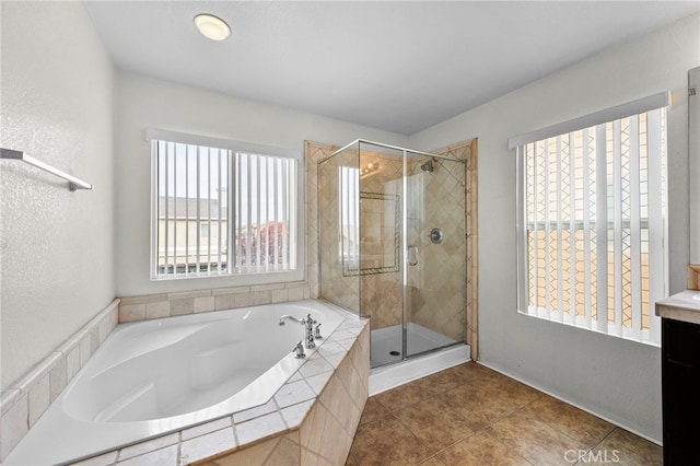 bathroom featuring a stall shower, tile patterned flooring, a garden tub, and vanity