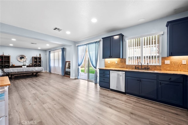 kitchen with light countertops, visible vents, stainless steel dishwasher, open floor plan, and a sink