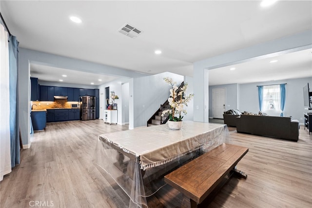 dining space with light wood-type flooring, visible vents, stairway, and recessed lighting