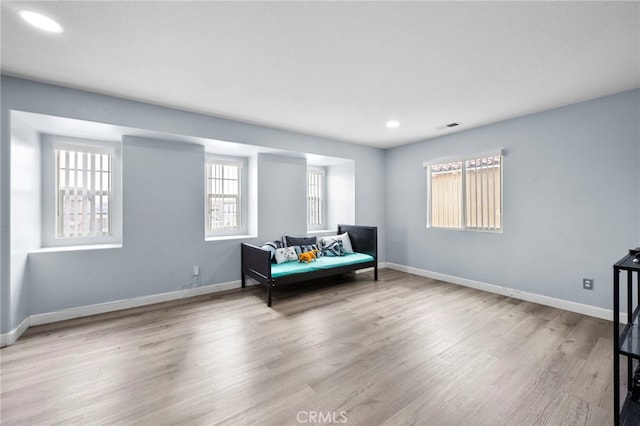 sitting room featuring light wood-style floors, visible vents, and baseboards