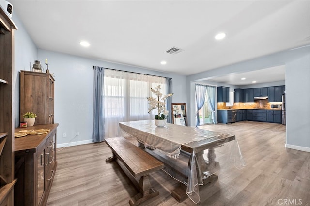 dining room featuring light wood-type flooring, baseboards, and visible vents