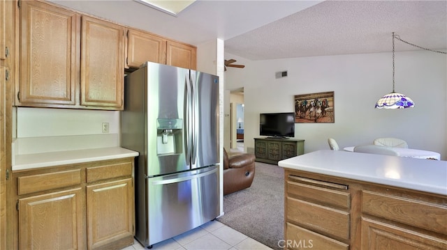 kitchen featuring lofted ceiling, stainless steel refrigerator with ice dispenser, hanging light fixtures, light tile patterned flooring, and ceiling fan