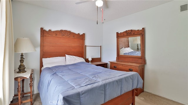 carpeted bedroom featuring a textured ceiling and ceiling fan