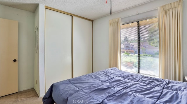 carpeted bedroom featuring a closet and a textured ceiling