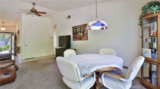 carpeted dining space featuring ceiling fan and vaulted ceiling