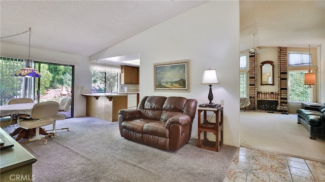 carpeted living room featuring a healthy amount of sunlight, a textured ceiling, and vaulted ceiling