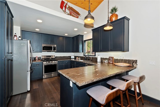 kitchen featuring kitchen peninsula, dark hardwood / wood-style flooring, blue cabinetry, pendant lighting, and stainless steel appliances