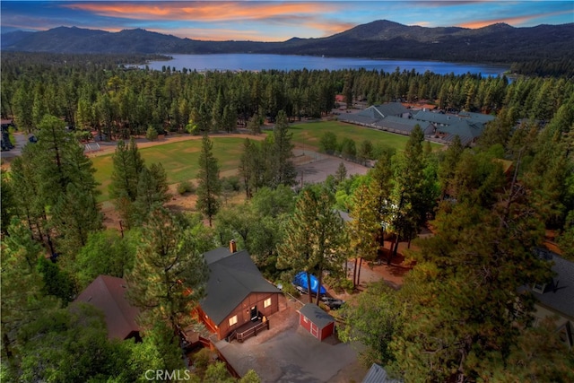 aerial view at dusk featuring a water and mountain view