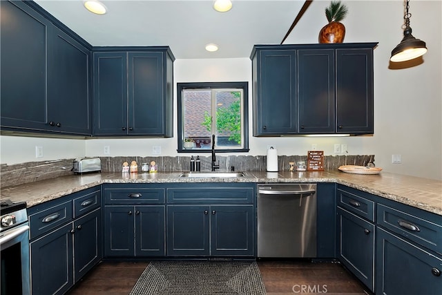 kitchen featuring appliances with stainless steel finishes, sink, pendant lighting, dark wood-type flooring, and blue cabinetry