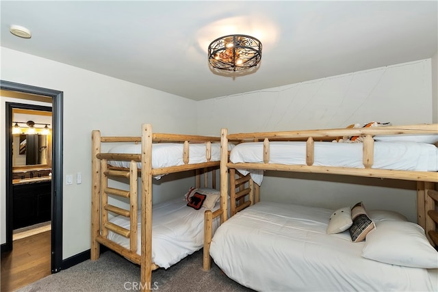 bedroom featuring connected bathroom, carpet flooring, and sink