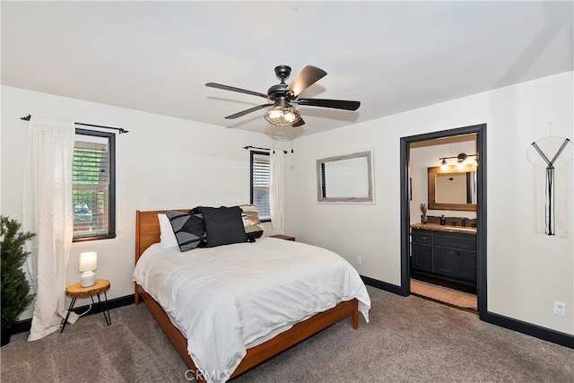 carpeted bedroom with ensuite bath, sink, and ceiling fan