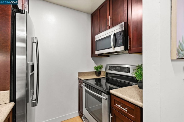 kitchen with light hardwood / wood-style flooring and appliances with stainless steel finishes