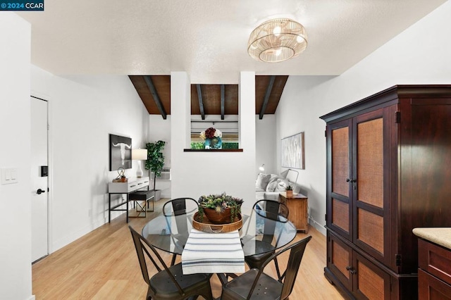 dining room with lofted ceiling with beams and light hardwood / wood-style floors