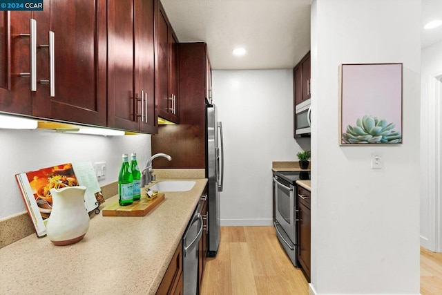 kitchen featuring sink, stainless steel appliances, and light wood-type flooring