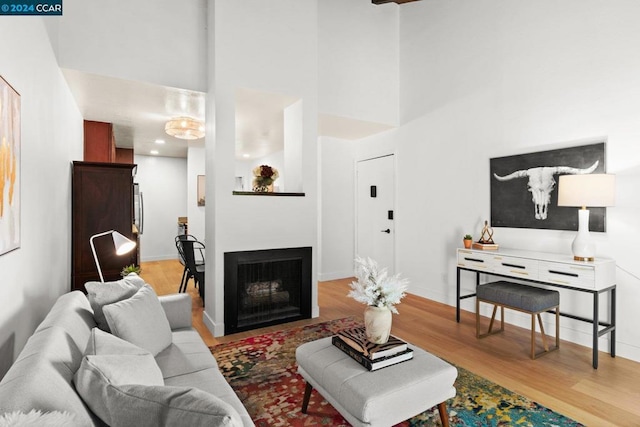 living room featuring a high ceiling and light wood-type flooring