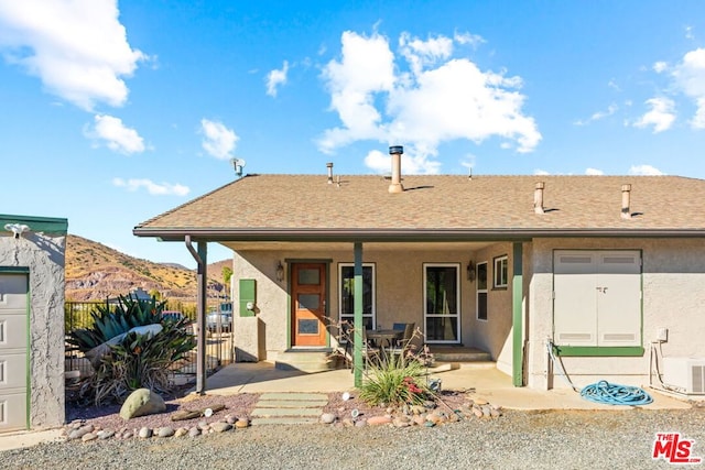 rear view of property featuring a patio and a mountain view