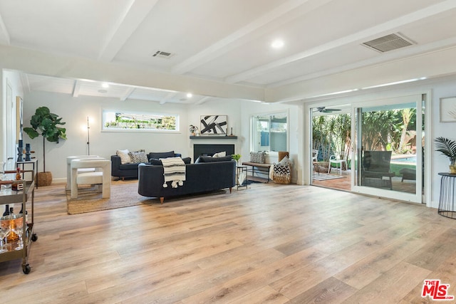 living room with plenty of natural light, beamed ceiling, and light hardwood / wood-style floors