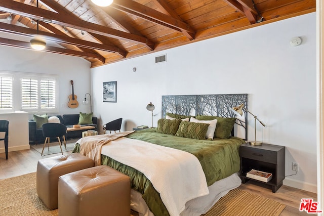 bedroom featuring vaulted ceiling with beams, light wood-type flooring, and wooden ceiling