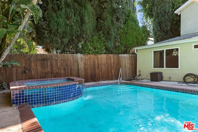 view of pool with pool water feature and an in ground hot tub