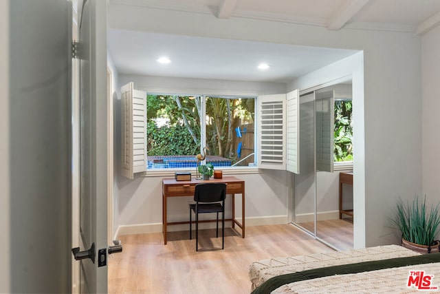 interior space featuring beamed ceiling, light wood-type flooring, and crown molding