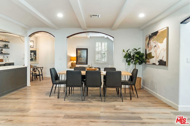 dining space featuring beam ceiling and light hardwood / wood-style flooring