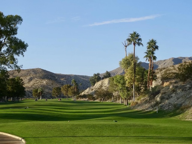 surrounding community with a mountain view and a lawn