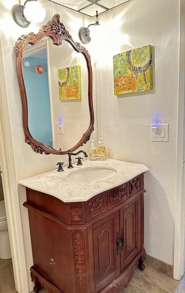 bathroom featuring toilet, tile patterned floors, and vanity