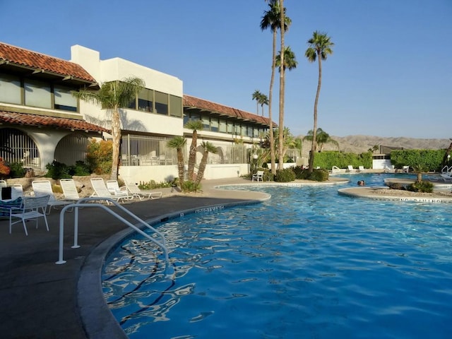 view of swimming pool with a patio area and a mountain view