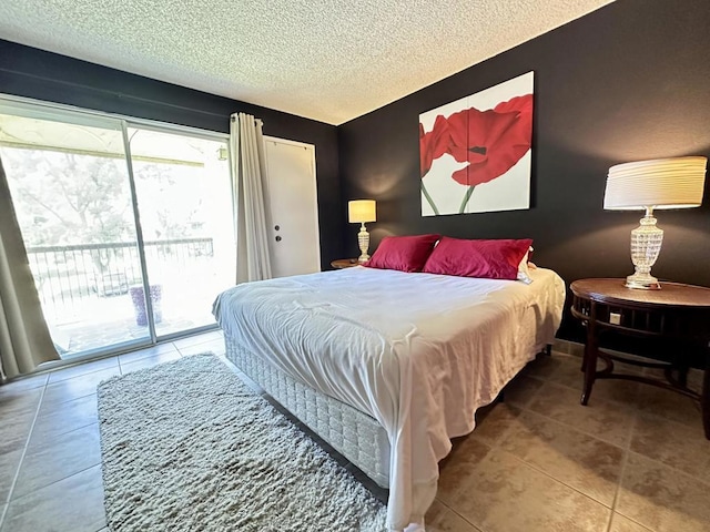 bedroom with access to outside, tile patterned floors, and a textured ceiling