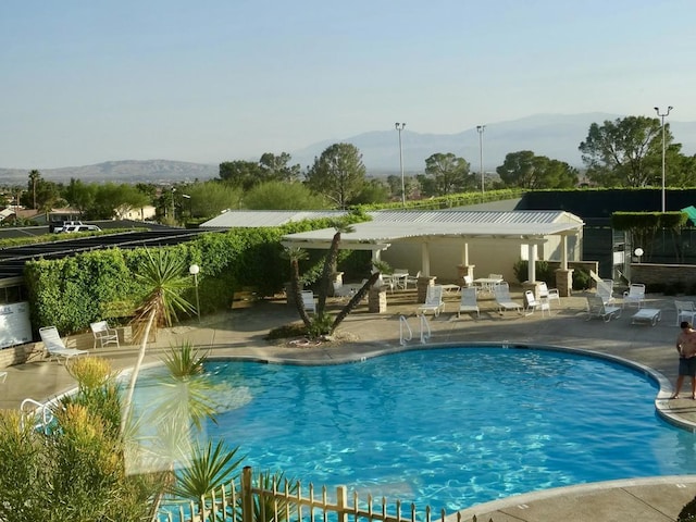 view of swimming pool with a pergola, a mountain view, and a patio