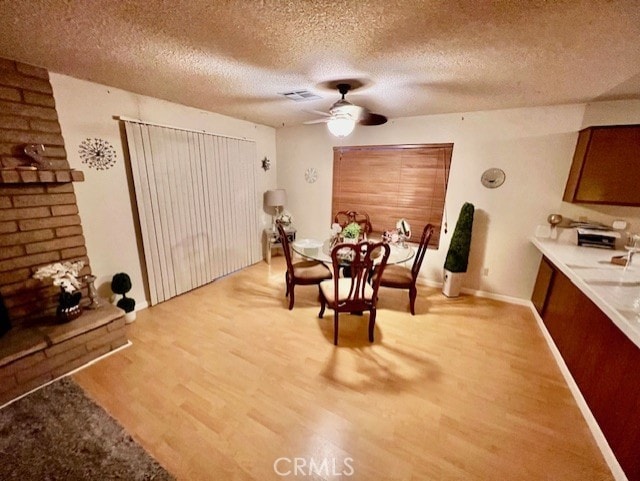 unfurnished dining area featuring a textured ceiling, light hardwood / wood-style flooring, and ceiling fan