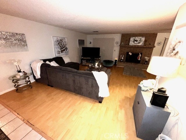 living room with hardwood / wood-style flooring and a brick fireplace