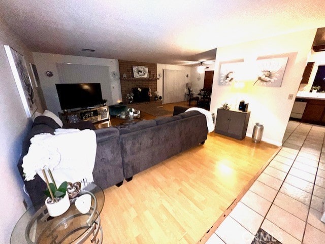 living room featuring a fireplace, a textured ceiling, and light hardwood / wood-style flooring