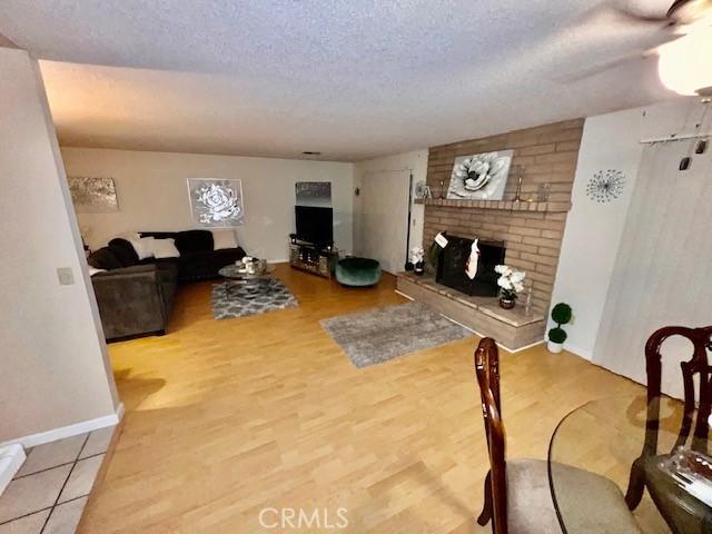 living room featuring hardwood / wood-style flooring, a textured ceiling, and a fireplace