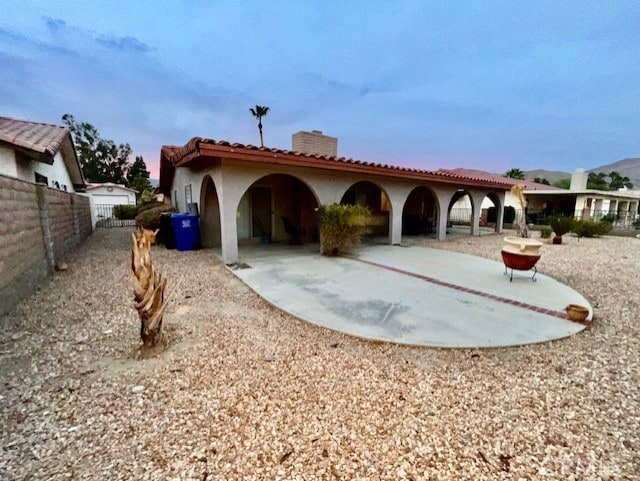 back house at dusk with a patio