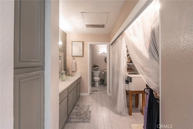 bathroom featuring vanity, hardwood / wood-style flooring, and toilet