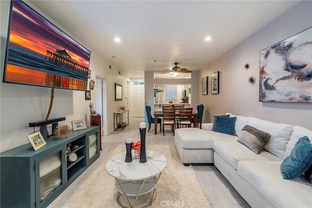 living room featuring light hardwood / wood-style floors and ceiling fan