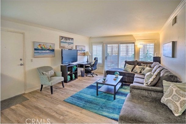 living room with wood-type flooring and ornamental molding