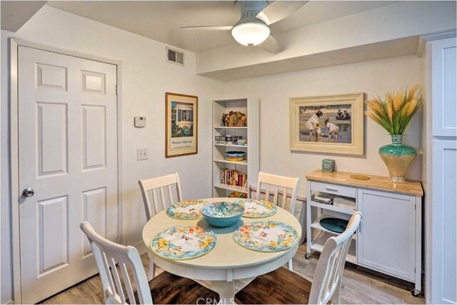 dining space with light hardwood / wood-style floors and ceiling fan