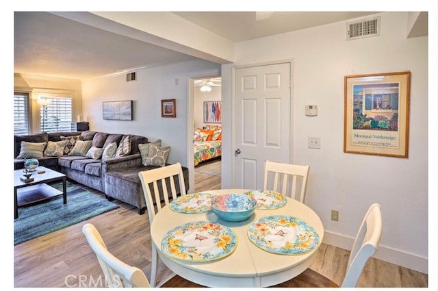 dining room with ceiling fan and light hardwood / wood-style flooring