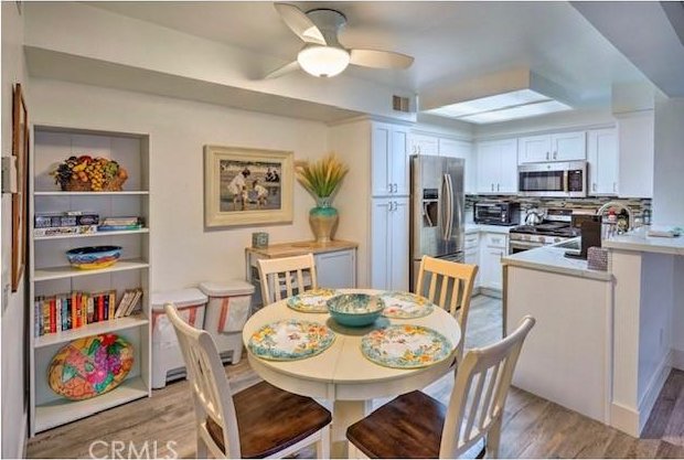 dining area featuring sink, light wood-type flooring, and ceiling fan