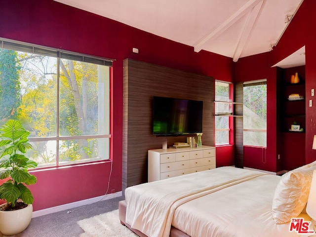 bedroom with light colored carpet, lofted ceiling with beams, and multiple windows