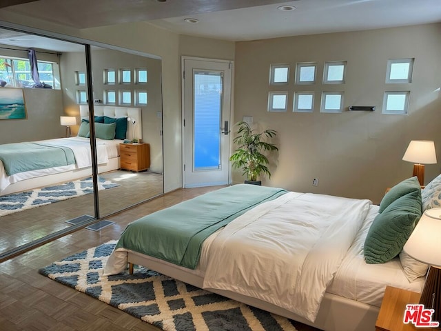 bedroom featuring a closet and light parquet floors