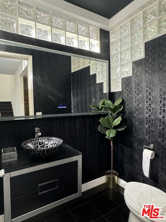 bathroom featuring vanity, tile patterned floors, and toilet