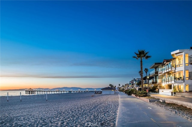 exterior space with a water view and a beach view