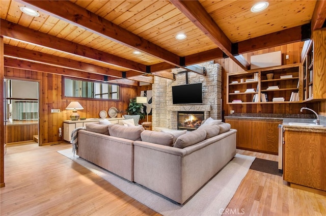 living room with wooden ceiling, light hardwood / wood-style flooring, wooden walls, and beamed ceiling