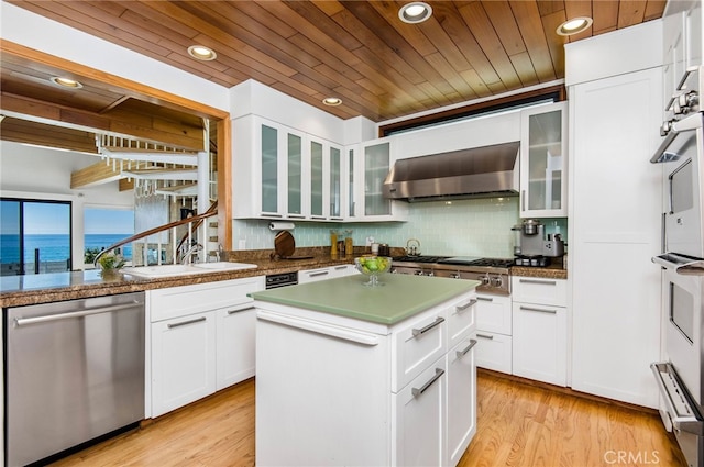 kitchen with a kitchen island, white cabinetry, stainless steel appliances, and a water view