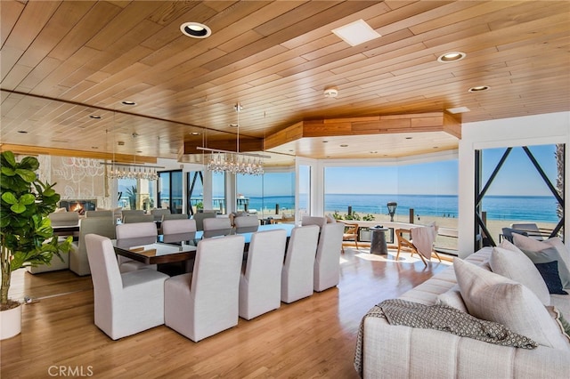 dining room featuring a water view, a healthy amount of sunlight, and wooden ceiling